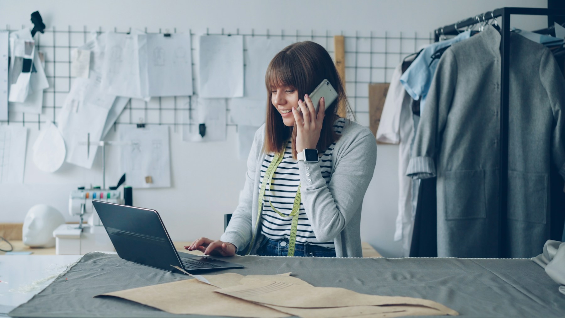 A small business owner speaking with a customer by phone in her studio